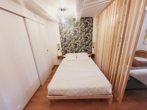 - une petite chambre avec un lit et un mur dans l'établissement Mahé , appartement Intramuros, à Avignon
