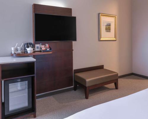 a room with a tv and a chair and a table at Garden Court East London in East London