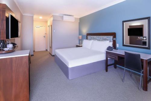 a hotel room with a bed and a desk with a computer at Garden Court East London in East London
