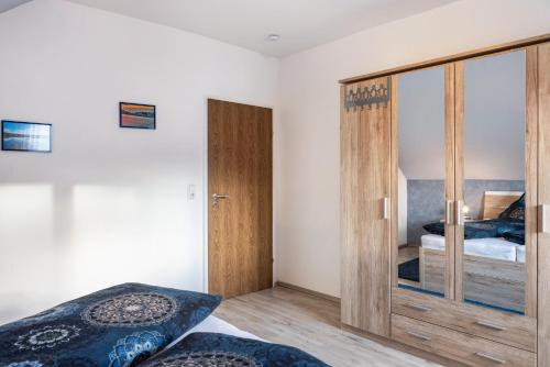 a bedroom with a bed and a sliding glass door at Ferienwohnung Schiller in Grebenhain