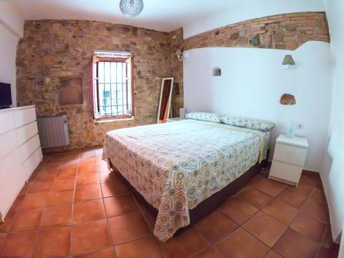 a bedroom with a bed and a stone wall at Casa de piedra en el casco antiguo de Sagunto in Sagunto