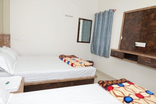 a room with two beds and a window at Shree Jyotirlinga Residency in Ellora