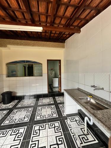 a bathroom with a sink and a tile floor at Casa Vista da Serra in São Roque de Minas