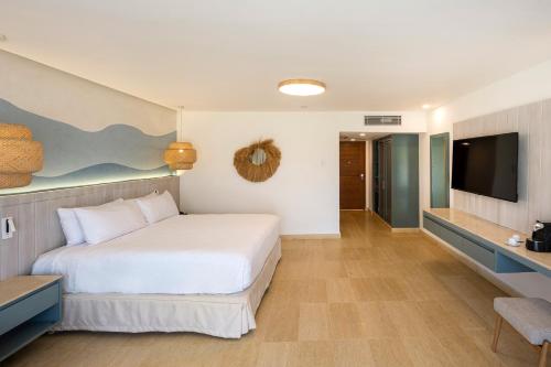 a bedroom with a bed and a flat screen tv at Viva Miches by Wyndham, a Trademark All Inclusive Resort in Miches