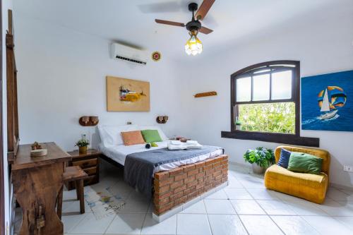 ein Schlafzimmer mit Bett, Schreibtisch und Fenster in der Unterkunft 300m da praia, AC, churrasqueira| Brazilian Corner in Toque Toque Grande
