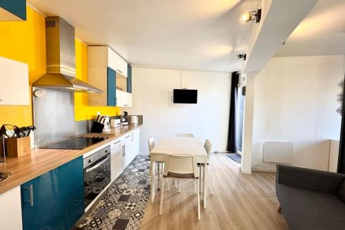 une cuisine avec une table et une salle à manger dans l'établissement Agréable maisonnette entièrement rénovée -Terrasse, à Guidel