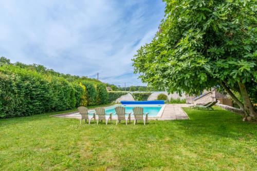 - un groupe de chaises assises dans l'herbe à côté d'une piscine dans l'établissement Maison de campagne sud Touraine avec piscine 8px, à Crouzilles