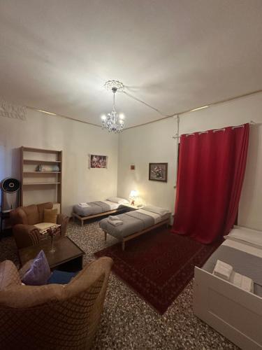 a living room with two beds and a red curtain at Rosa apartment in Venice