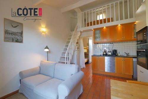 un salon avec un canapé blanc et une cuisine dans l'établissement Le Cabanon, à Sausset-les-Pins