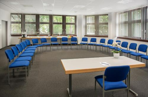 a conference room with blue chairs and a table and blue chairs at Atrium im Park Hotel Regensburg in Regensburg