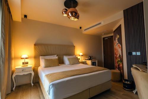 a bedroom with a large white bed with two lamps at Santa Lucia Boutique Hotel in Santa Luċija