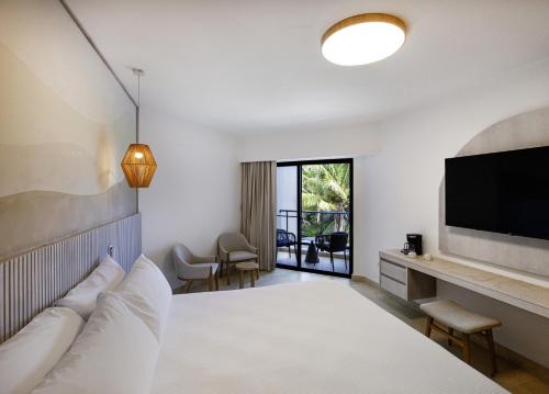 a hotel room with a bed and a flat screen tv at Viva Miches by Wyndham, a Trademark All Inclusive Resort in Miches