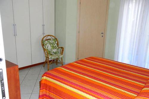 ジュリアノーヴァにあるAppartamento Bluのベッドルーム1室(ベッド1台、椅子、キャビネット付)