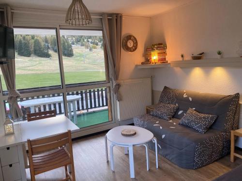 un salon avec un canapé et une table dans l'établissement Le studio de Camille, à Saint-Étienne-en-Dévoluy