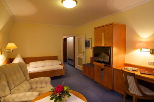 a hotel room with a bed and a television at Chateau Fontenay in Bad Wörishofen