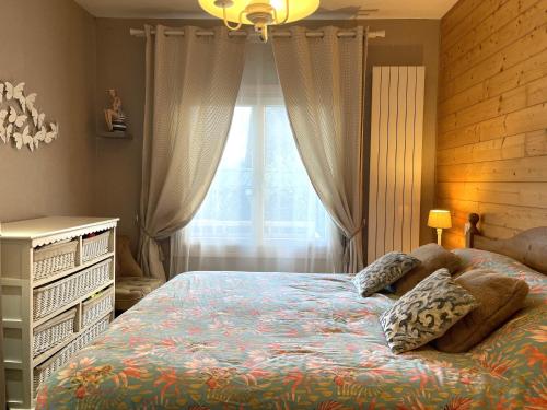 une chambre avec un lit avec des oreillers et une fenêtre dans l'établissement Maison avec jardin, terrasse, WIFI au centre de PERROS-GUIREC - Réf 949, à Perros-Guirec