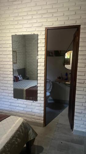 a mirror in a room with a bed and a bathroom at Chalés de Imbassaí - Chalé 4 in Mata de Sao Joao