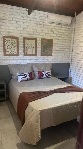 a bedroom with a large bed with pillows on it at Chalés de Imbassaí - Chalé 4 in Mata de Sao Joao