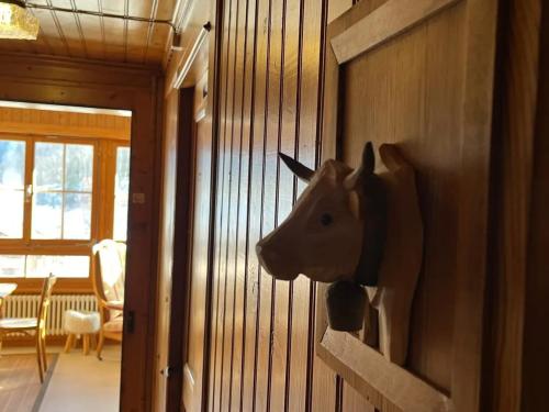 a wooden cow head on the wall of a room at Spacious House with Mountain View in Haut-Intyamon in Les Sciernes d'Albeuve