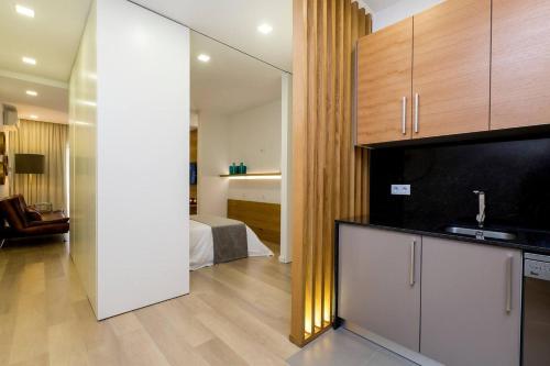 a living room with a kitchen and a bedroom at The Office Guest in Guimarães