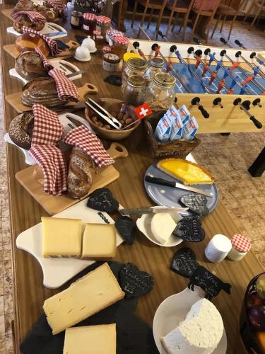 a table filled with cheese and other food items at Spacious House with Mountain View in Haut-Intyamon in Les Sciernes d'Albeuve