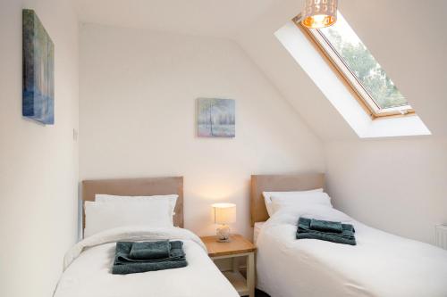 two twin beds in a room with a window at School Lodge in Llandeilo