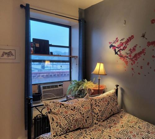 a bedroom with a bed and a large window at My apartment in New York