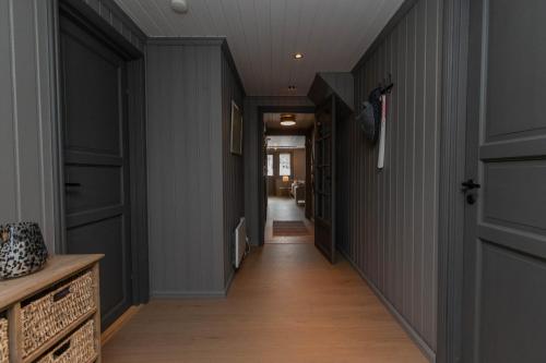 a hallway with grey walls and wooden floors and doors at Newly renovated cabin in Nesfjellet, Nesbyen in Nesbyen