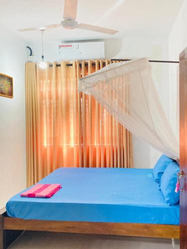 a bedroom with a bed with a mosquito net at Sea Side Bay House in Weligama