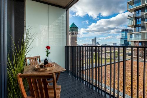 a balcony with a table and a view of the city at Kairos Apartments - Manhattan Premium-klimatyzacja-siłownia-sala kinowa in Katowice