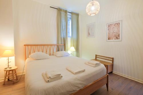 Un dormitorio con una cama con toallas. en Séjour Cosy, Périgueux, en Périgueux