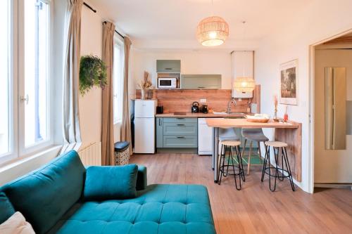 un salon avec un canapé bleu et une cuisine dans l'établissement Le Relais des Depeches, à Périgueux