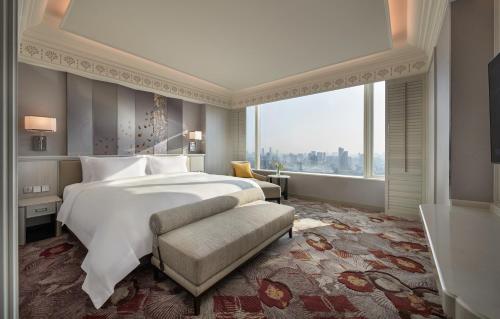 a bedroom with a large bed and a large window at Grande Centre Point Lumphini Bangkok in Bangkok