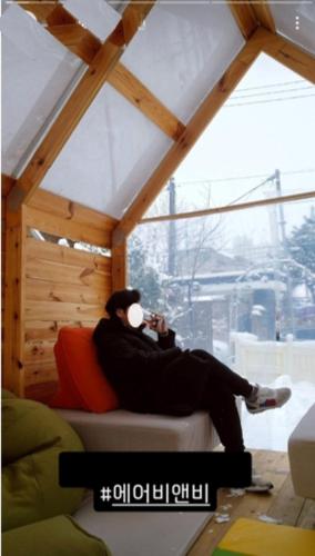 a man sitting on a couch talking on a cell phone at Wonju Aunt Home in Wonju
