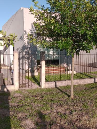 un árbol frente a una valla frente a un edificio en Casa KAIROS, en Federación