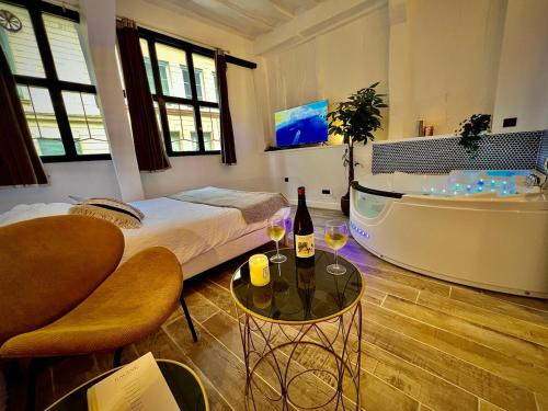 a room with a tub and a bed and a bottle of wine at Le Spa Corneille - Jacuzzi, Sauna & Parking par Rouen Atypique in Rouen