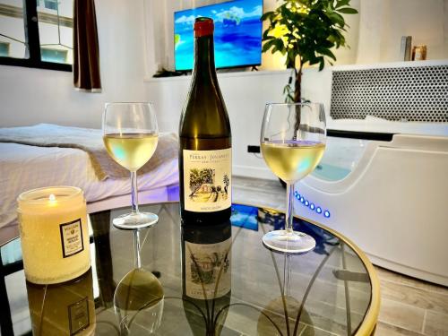 une bouteille de vin et deux verres sur une table dans l'établissement Le Spa Corneille - Jacuzzi, Sauna & Parking par Rouen Atypique, à Rouen