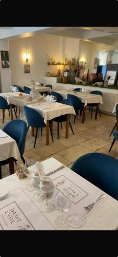 un restaurant avec des tables blanches et des chaises bleues dans l'établissement restaurant Dame L'Oie, à Pernes-les-Fontaines