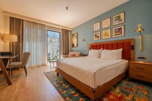 a bedroom with a bed and a desk and a chair at Sundia Exclusive By Liberty Fethiye Adults Only in Fethiye