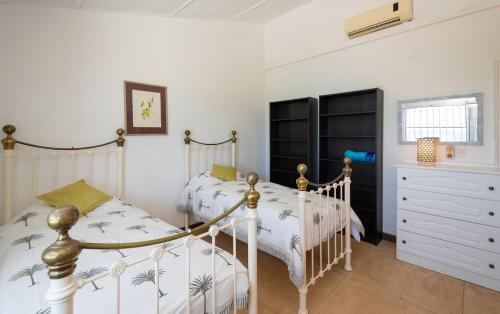 a bedroom with two twin beds and a dresser at Villa La HOULE- beachfront,private pool,3 bedrooms in Cap Malheureux