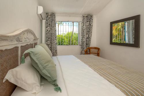 a bedroom with a large bed with a window at Villa La HOULE- beachfront,private pool,3 bedrooms in Cap Malheureux