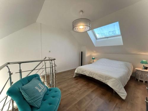une chambre avec un lit et une chaise dedans dans l'établissement Appartement avec mezzanine, piscine et parking - proche plage et clubs sportifs à La Baule - FR-1-245-43, à Guérande