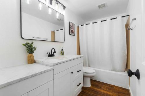 ein Badezimmer mit Waschbecken, Toilette und Spiegel in der Unterkunft Luxury Living - Kirkland Stylish Home - Prime Spot in Kirkland
