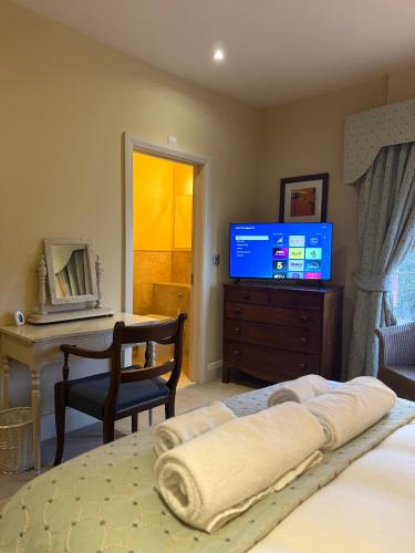 a bedroom with a bed with a television and a desk at The Old Hunting Lodge at The Talbot Inn in Tenbury