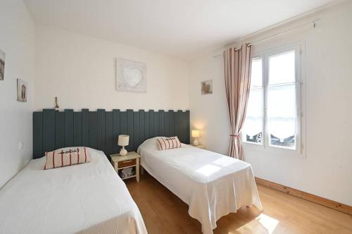 ein Schlafzimmer mit zwei Betten und einem Fenster in der Unterkunft Villa Coraly - piscine chauffée et jardin in Sainte-Marie-de-Ré