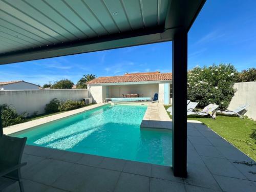 une piscine dans l'arrière-cour d'une maison dans l'établissement Villa Coraly - piscine chauffée et jardin, à Sainte-Marie de Ré