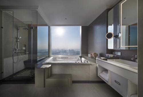 a bathroom with a bath tub and a window at Grande Centre Point Lumphini Bangkok in Bangkok