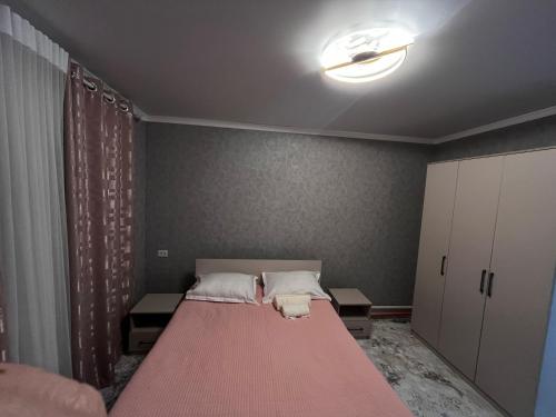 una camera da letto con un letto grande con una coperta rossa di Private house a Karakol