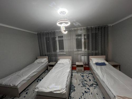 una stanza con due letti e un lampadario di Private house a Karakol
