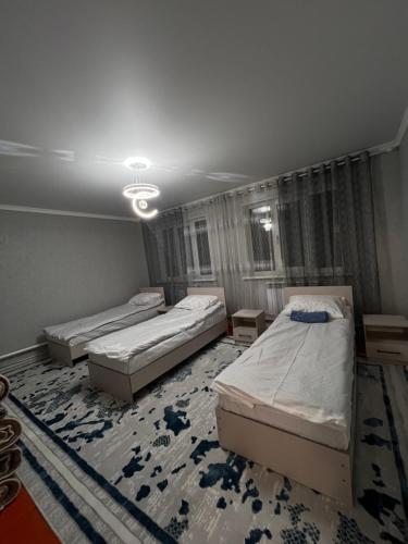 una stanza con tre letti e un tappeto di Private house a Karakol